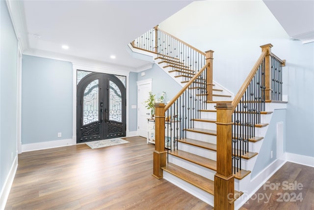 entrance foyer featuring hardwood / wood-style flooring, crown molding, and french doors