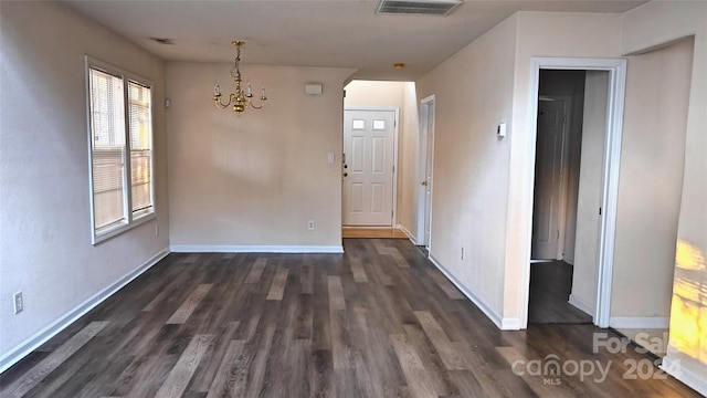 unfurnished dining area with an inviting chandelier and dark wood-type flooring