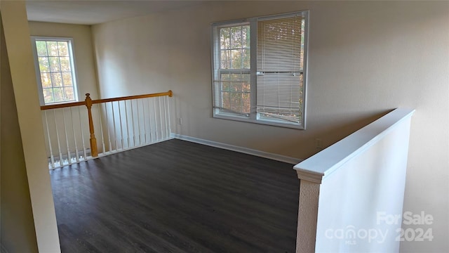 unfurnished room with dark hardwood / wood-style flooring