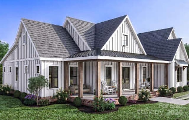 rear view of house featuring covered porch and a yard