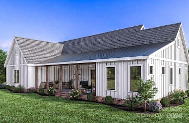 rear view of house featuring a yard