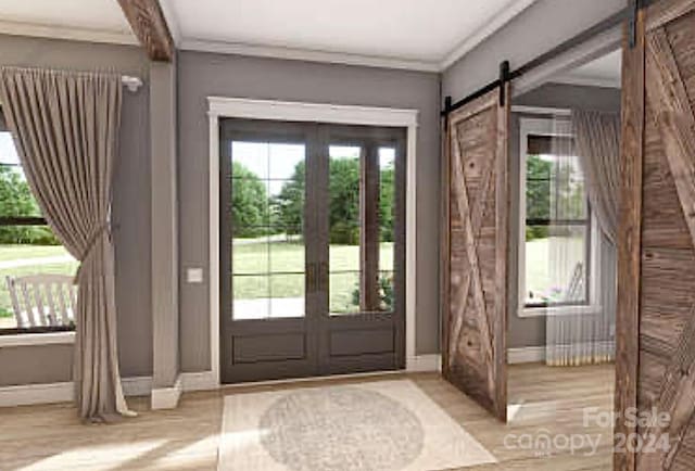 doorway to outside with a barn door, crown molding, french doors, and light wood-type flooring