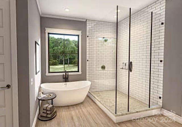 bathroom featuring hardwood / wood-style floors, crown molding, and plus walk in shower