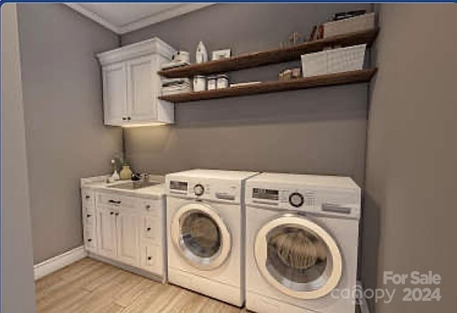 laundry room with sink, cabinets, crown molding, washer and clothes dryer, and light wood-type flooring