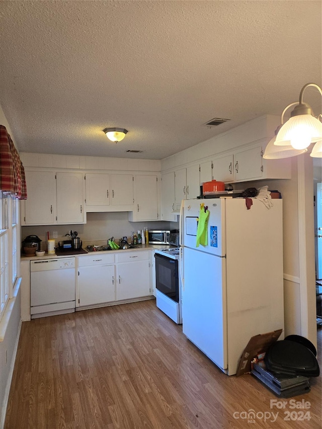 kitchen featuring a textured ceiling, white cabinetry, light hardwood / wood-style flooring, and white appliances