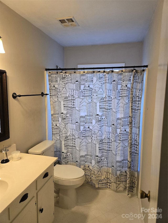 bathroom with tile patterned floors, vanity, curtained shower, and toilet