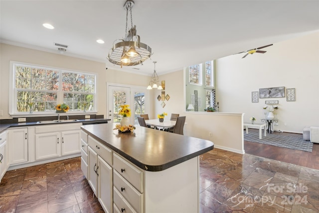 kitchen with french doors, sink, hanging light fixtures, ceiling fan, and a kitchen island