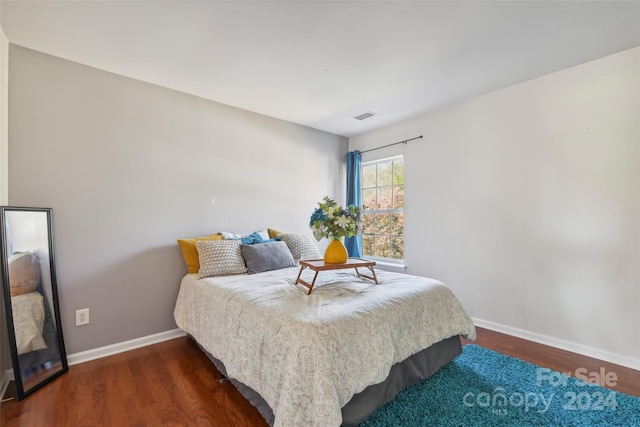 bedroom with dark hardwood / wood-style floors