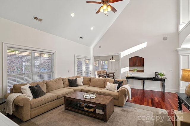 living room with hardwood / wood-style floors, high vaulted ceiling, and ceiling fan with notable chandelier