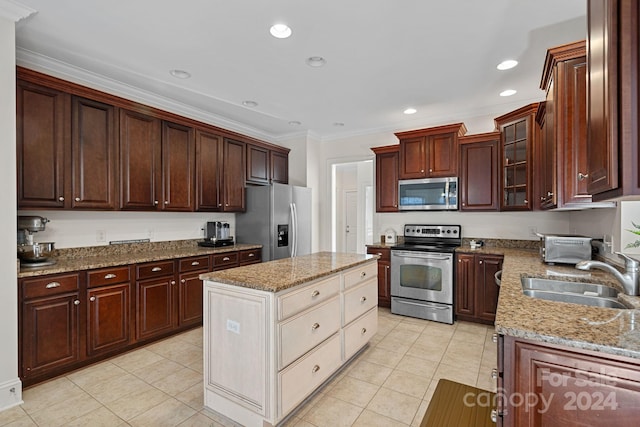 kitchen featuring appliances with stainless steel finishes, crown molding, sink, light tile patterned floors, and a kitchen island