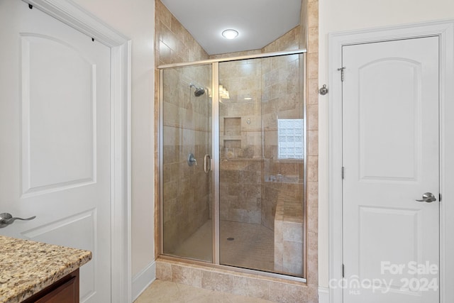 bathroom featuring vanity, tile patterned floors, and a shower with shower door