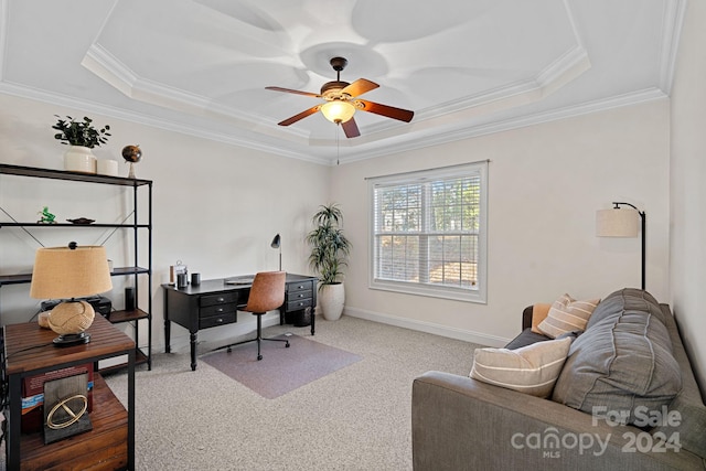 office space with a tray ceiling, ceiling fan, carpet flooring, and ornamental molding