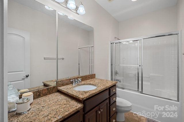 full bathroom featuring shower / bath combination with glass door, vanity, toilet, and tile patterned flooring