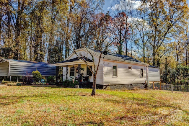 view of front of house with a carport, a porch, and a front lawn