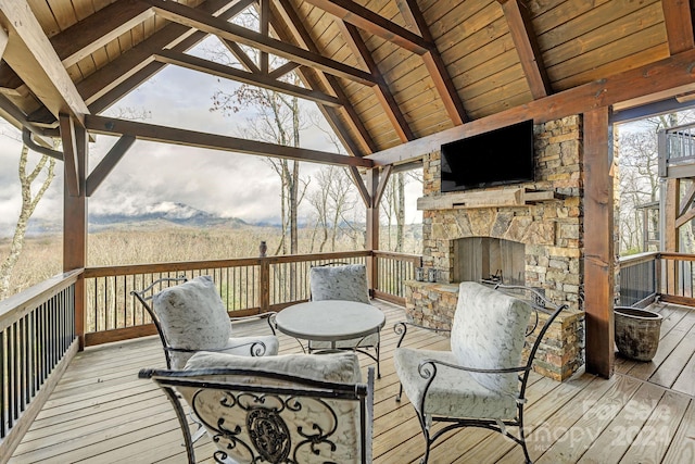 wooden deck featuring a gazebo and an outdoor stone fireplace