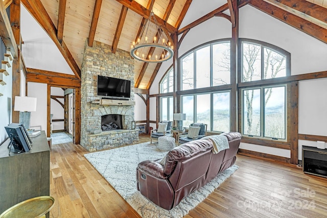 living room with high vaulted ceiling, light wood-type flooring, a fireplace, beam ceiling, and a chandelier