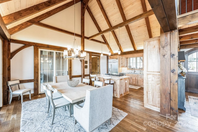 dining area featuring beam ceiling, hardwood / wood-style flooring, wood ceiling, and sink