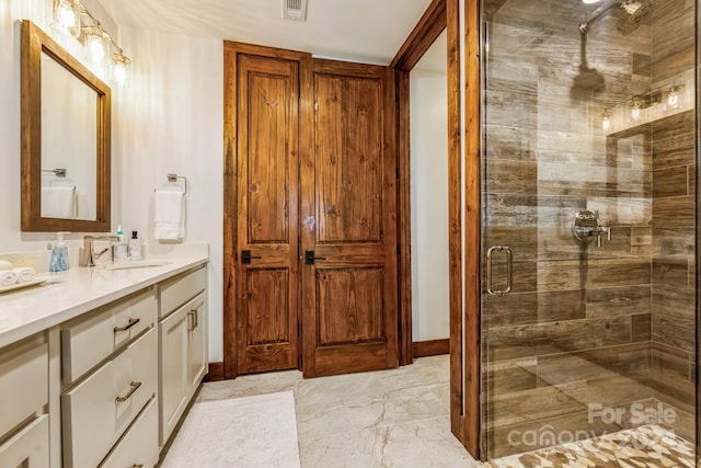 bathroom with vanity and a shower with door