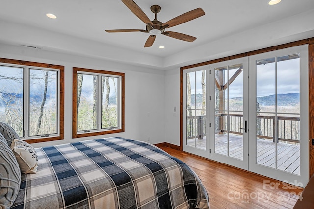 bedroom with access to outside, a mountain view, ceiling fan, and wood-type flooring