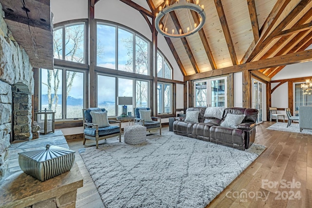 living room with beam ceiling, wooden ceiling, an inviting chandelier, high vaulted ceiling, and light hardwood / wood-style floors