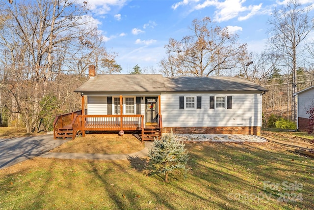 view of front of property with a wooden deck and a front yard