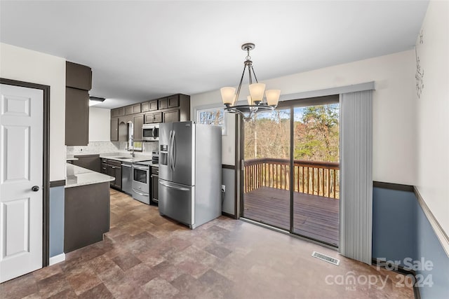 kitchen featuring decorative backsplash, dark brown cabinets, stainless steel appliances, sink, and an inviting chandelier