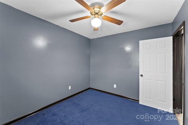 empty room with ceiling fan, carpet floors, and a textured ceiling