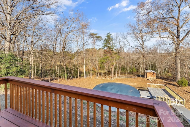 deck featuring a swimming pool and a storage shed