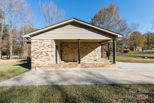 view of home's exterior with a yard and a carport