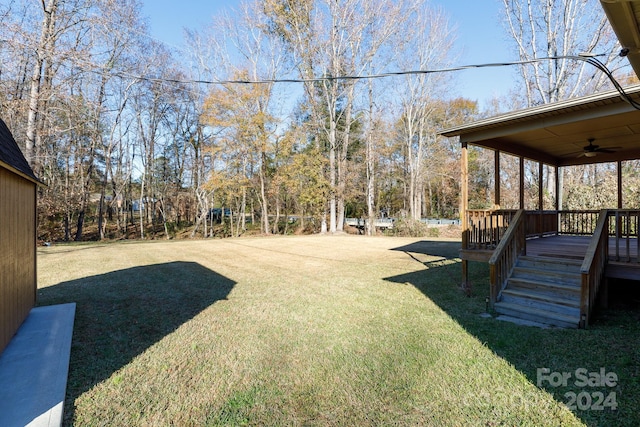 view of yard featuring a deck and ceiling fan