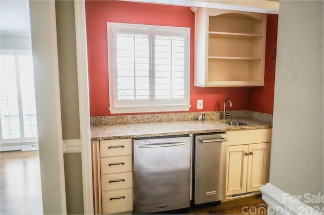 kitchen with light stone counters, plenty of natural light, stainless steel dishwasher, and sink