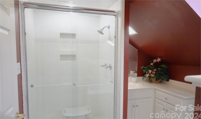 bathroom featuring vanity, vaulted ceiling, and walk in shower