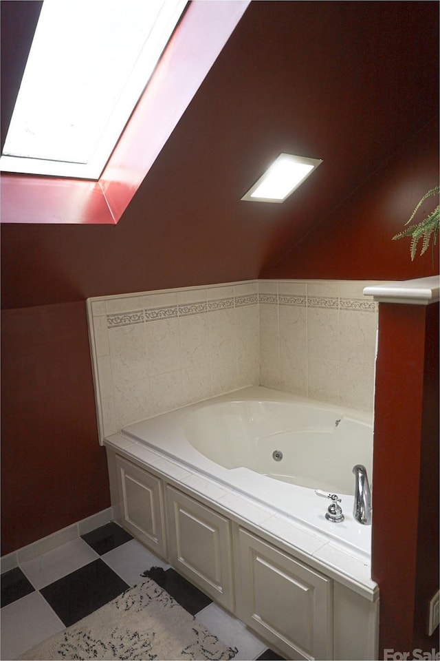 bathroom featuring lofted ceiling with skylight and a washtub