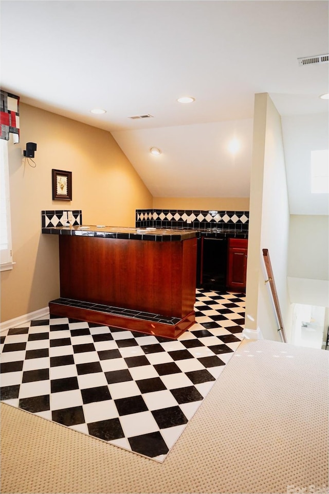 kitchen with dark carpet and vaulted ceiling