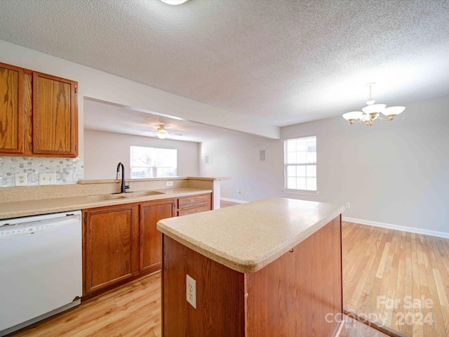 kitchen with white dishwasher, light hardwood / wood-style flooring, plenty of natural light, and sink