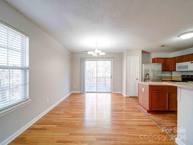 kitchen featuring stainless steel appliances, plenty of natural light, and light hardwood / wood-style floors