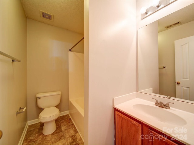 full bathroom featuring shower / bathing tub combination, vanity, toilet, and a textured ceiling