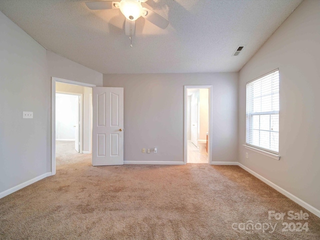 carpeted spare room featuring ceiling fan and a textured ceiling