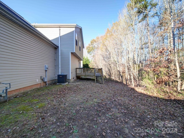 view of yard with a deck and central AC