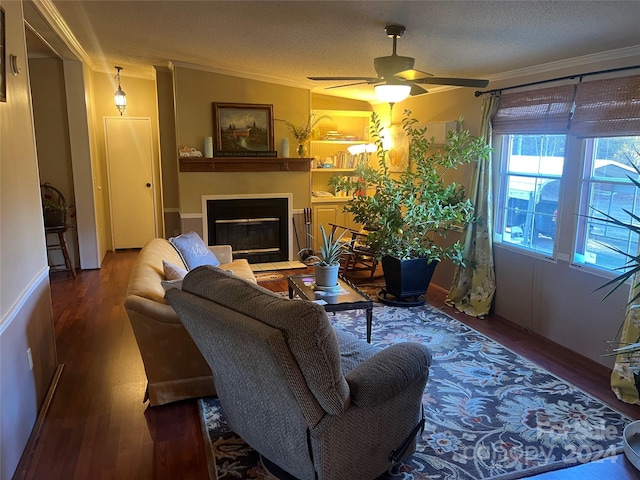 living room with ceiling fan, wood-type flooring, a textured ceiling, and ornamental molding