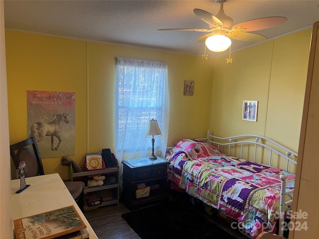 bedroom featuring ceiling fan, hardwood / wood-style floors, and a textured ceiling