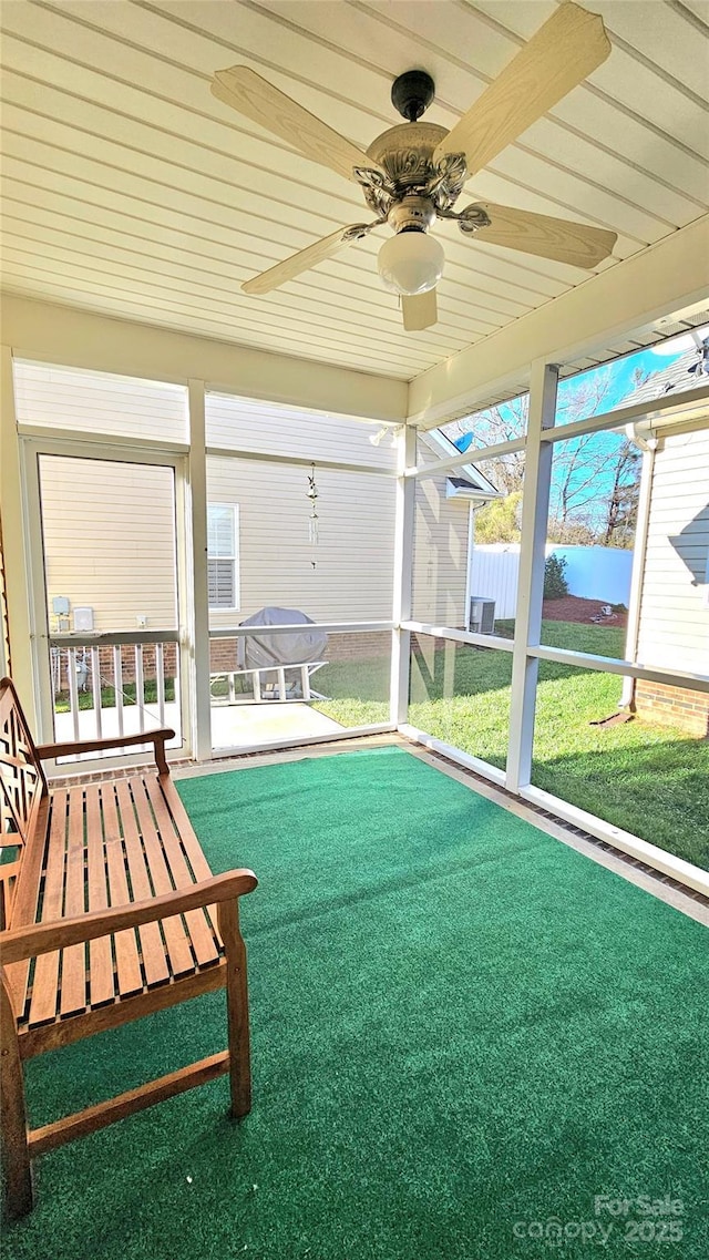 unfurnished sunroom with ceiling fan and a healthy amount of sunlight