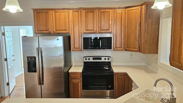 kitchen with sink, stainless steel appliances, and pendant lighting