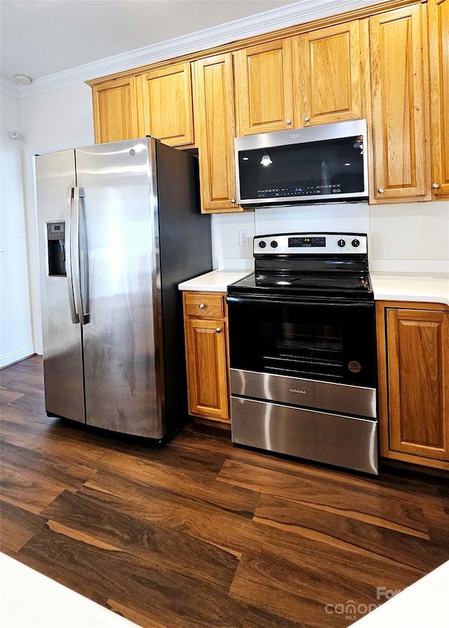 kitchen featuring dark wood-type flooring, appliances with stainless steel finishes, and ornamental molding