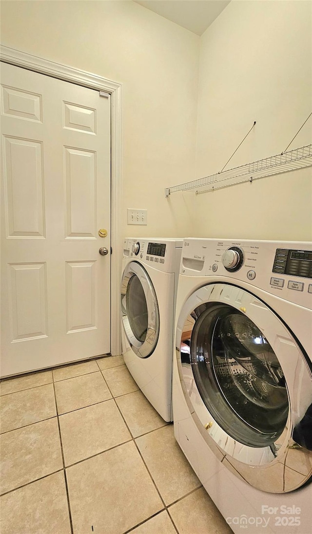 laundry room with light tile patterned floors and washing machine and clothes dryer