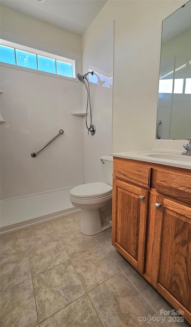 bathroom featuring a shower, tile patterned floors, toilet, and vanity