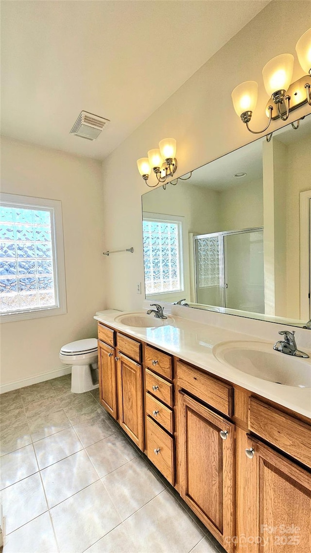 bathroom featuring tile patterned flooring, vanity, toilet, a notable chandelier, and a shower with shower door