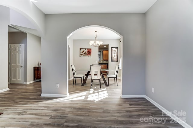 unfurnished dining area featuring dark hardwood / wood-style flooring and a notable chandelier