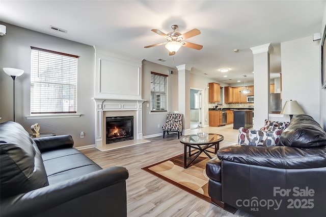 living room with ceiling fan and light hardwood / wood-style flooring