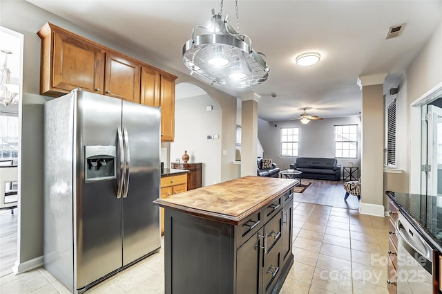 kitchen with ceiling fan, appliances with stainless steel finishes, a center island, and light tile patterned flooring